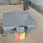 Close up of a heavy duty industrial floor scale showing the robust base and thickened steel deck