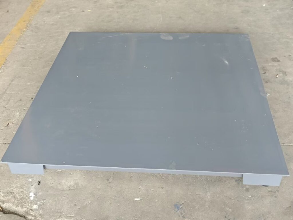 Close up of a heavy duty industrial floor scale showing the robust base and thickened steel deck