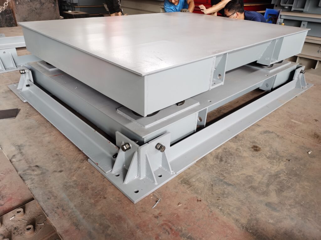 Close up of a heavy duty industrial floor scale showing the robust base and thickened steel deck